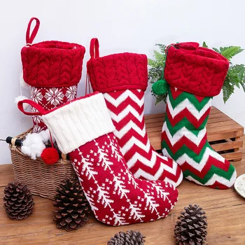 Új díszek, kötött karácsonyi harisnya, gyapjúharisnya, piros és fehér jávorszarvas ajándékcsomagok, gyermek ajándékcsomagok